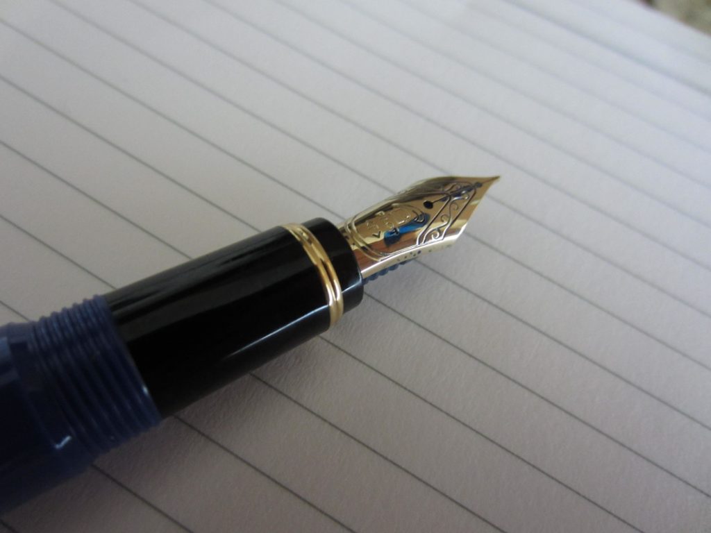A fountain pen on a blank lined page. 