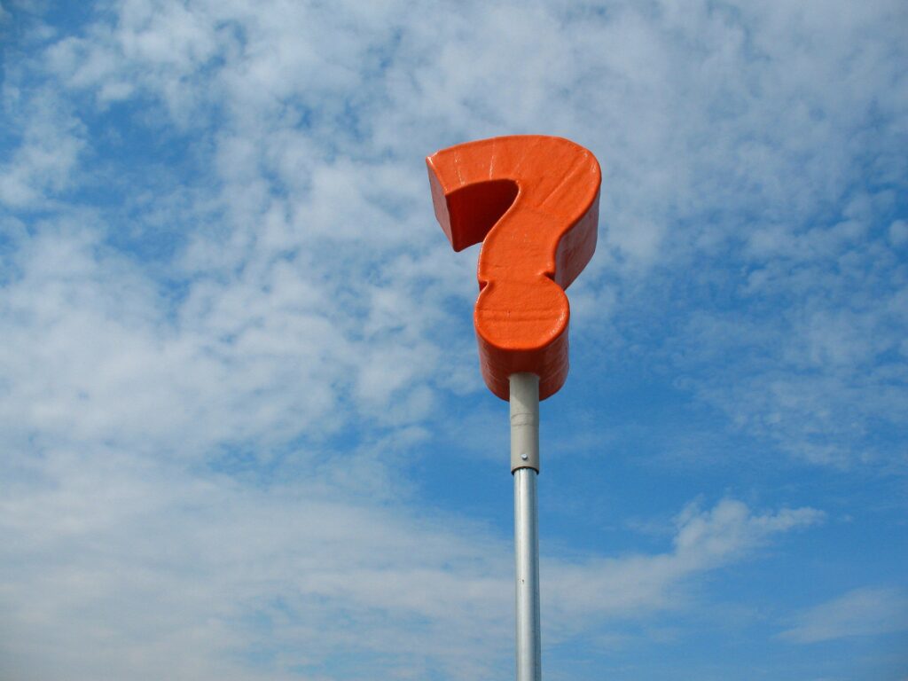A red question mark sign on a pole. 