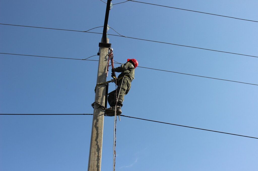 An electrician climbing a utility pole. 
